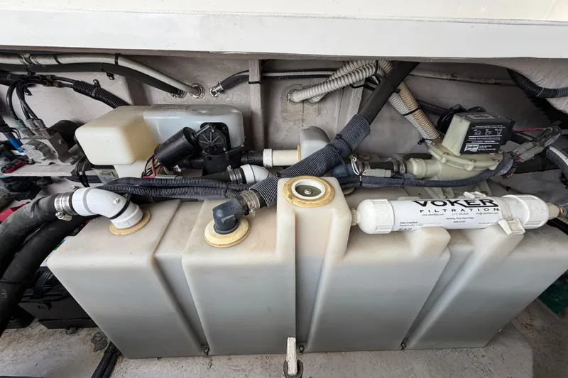 Slide: The Image of Engine compartment of a 2003 Sea Ray 420 Sundancer, showcasing filtration and plumbing systems. - 63