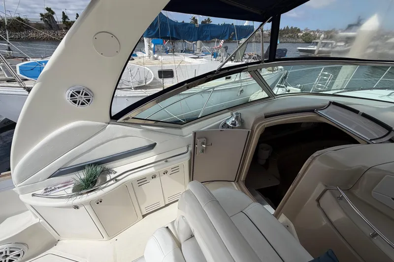 Slide: The Image of 2003 Sea Ray 420 Sundancer yacht interior with white seating and marina view. - 7