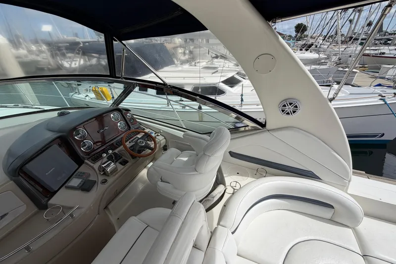 Slide: The Image of Cockpit of 2003 Sea Ray 420 Sundancer yacht with luxurious white seating and control panel. - 8