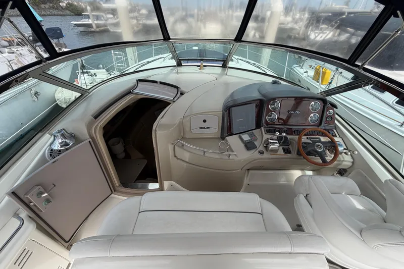 Slide: The Image of 2003 Sea Ray 420 Sundancer helm with modern controls and luxurious seating. - 9