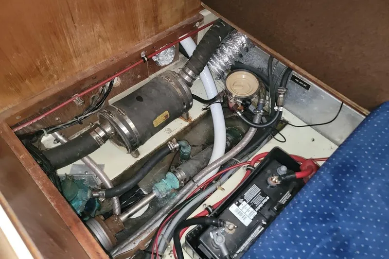 Slide: The Image of Engine compartment of a 1986 Pearson 28 sailboat, showing battery and mechanical components. - 11