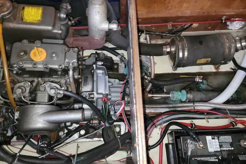 Slide: The Image of Engine compartment of a 1986 Pearson 28 sailboat, showing mechanical components and wiring. - 12