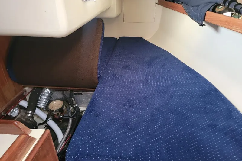 Slide: The Image of Interior cabin of a 1986 Pearson 28 sailboat with blue upholstery and visible engine components. - 14