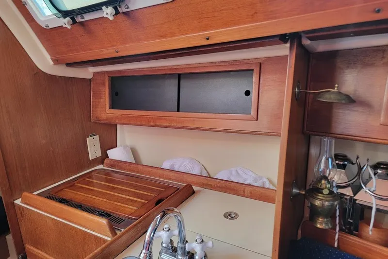 Slide: The Image of 1986 Pearson 28 sailboat interior with wooden cabinetry and vintage lamp. - 19