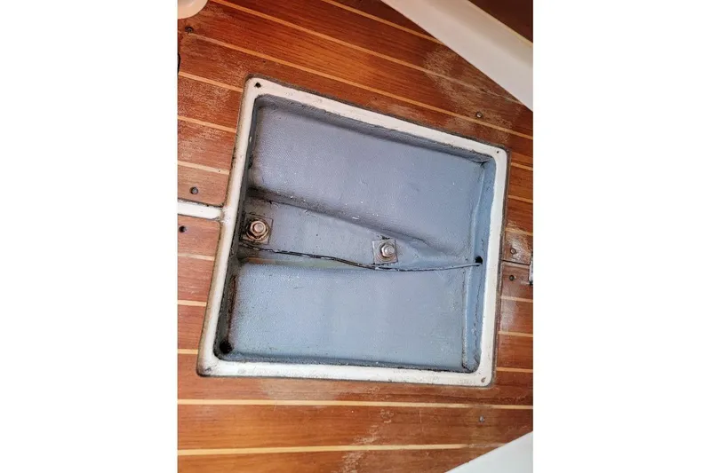Slide: The Image of Wooden deck hatch on a 1986 Pearson 28 sailboat, featuring a secured cover. - 22