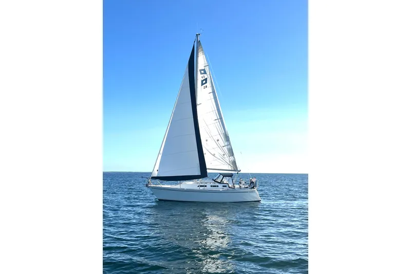 Slide: The Image of 1986 Pearson 28 sailboat gliding on calm blue waters under a clear sky. - 24