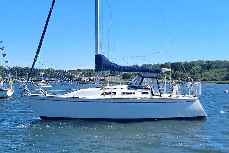 Slide: The Image of 1986 Pearson 28 sailboat on calm water, clear sky, and scenic background. - 28