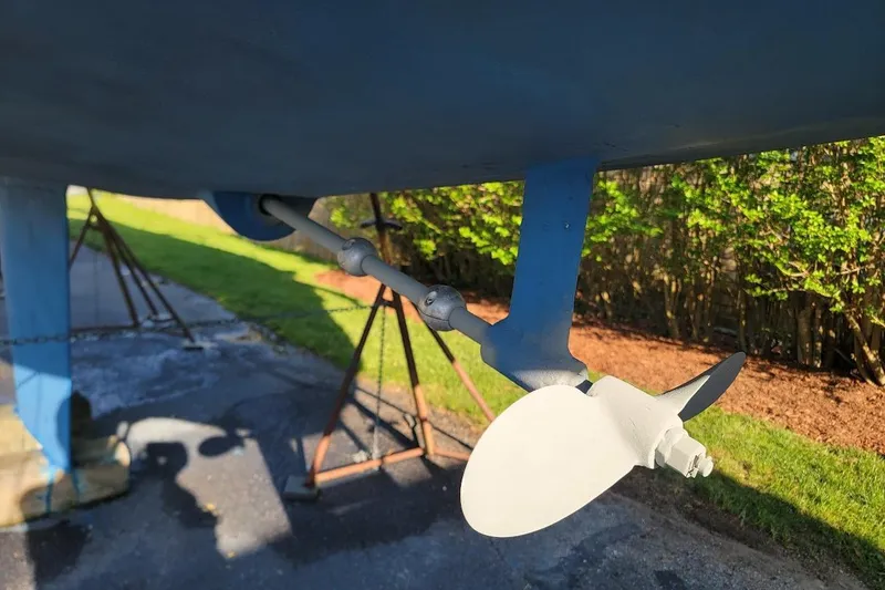 Slide: The Image of 1986 Pearson 28 sailboat propeller and rudder, displayed on stands outdoors. - 3
