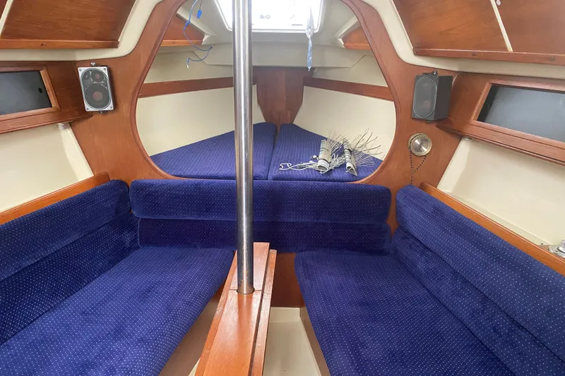 Slide: The Image of Interior of a 1986 Pearson 28 sailboat with blue upholstery and wooden accents. - 6