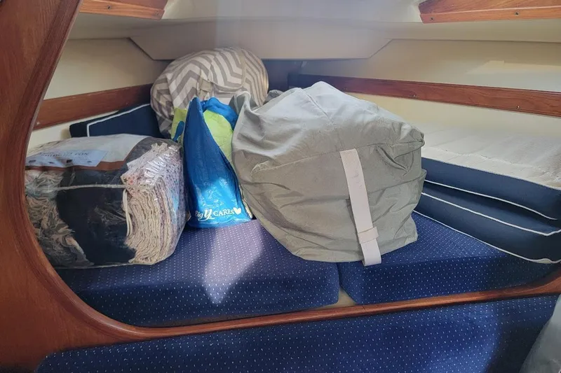 Slide: The Image of Interior of a 1986 Pearson 28 sailboat with cushions and stored items. - 7