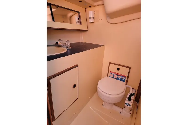 Slide: The Image of 1986 Pearson 28 yacht bathroom with sink, mirror, and marine toilet. - 9