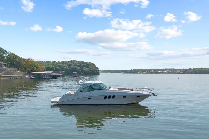 Slide: The Image of 2006 Sea Ray 48 Sundancer yacht on calm lake under blue sky. - 10