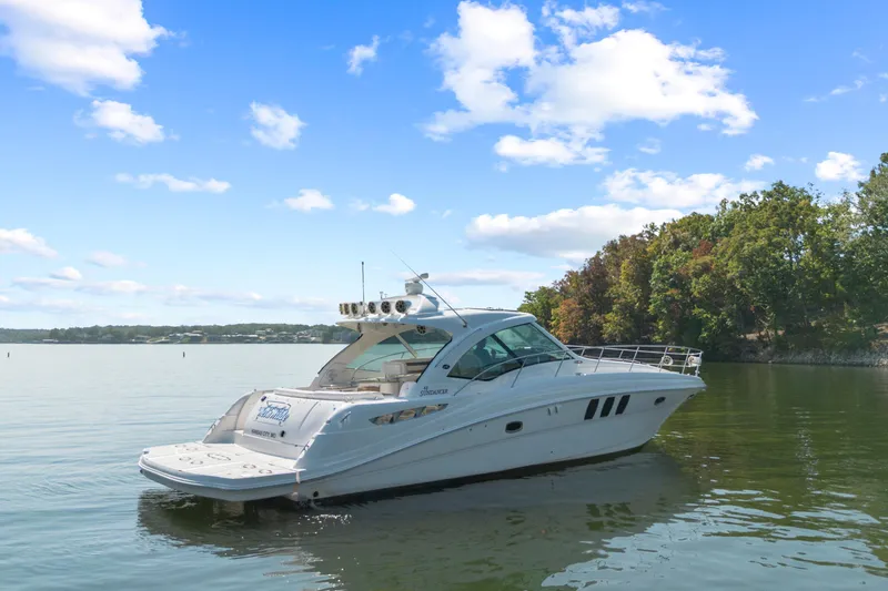 Slide: The Image of 2006 Sea Ray 48 Sundancer yacht on calm water with scenic background. - 3