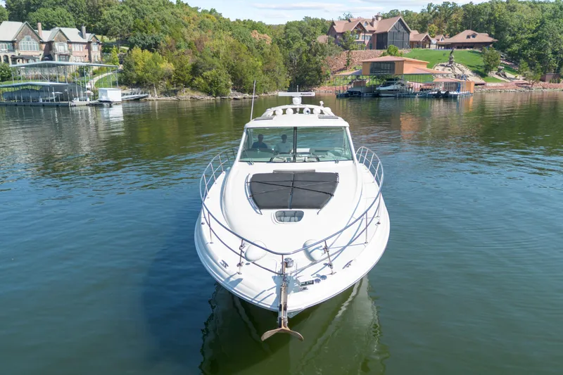Slide: The Image of 2006 Sea Ray 48 Sundancer yacht on a serene lake with waterfront homes. - 6