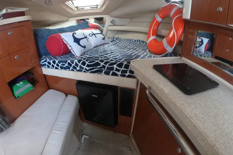 Slide: The Image of Interior of 2005 Regal Commodore 2860 boat with cozy bed and nautical decor. - 10