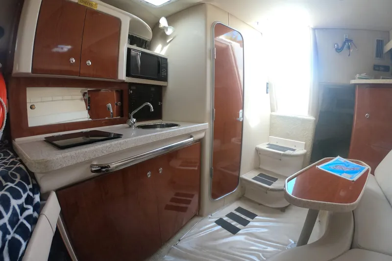 Slide: The Image of Interior of 2005 Regal Commodore 2860 boat, featuring kitchenette and seating area. - 12