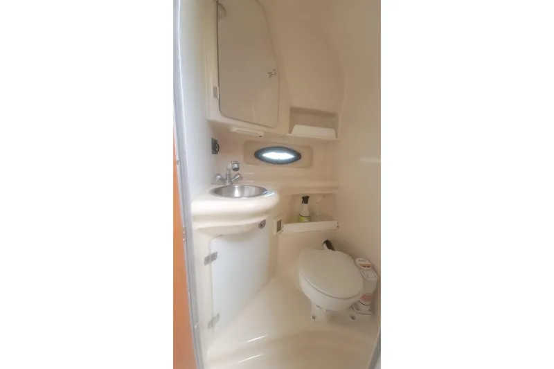 Slide: The Image of 2005 Regal Commodore 2860 boat bathroom with sink, toilet, and storage shelves. - 14