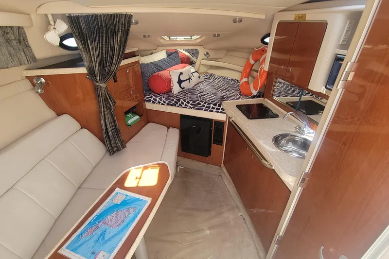 Slide: The Image of Interior of 2005 Regal Commodore 2860 boat with cozy seating and compact kitchen area. - 17