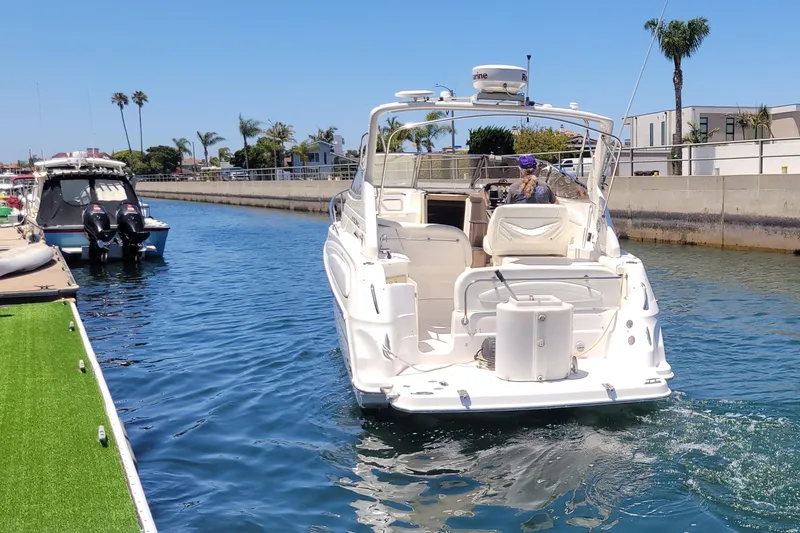 Slide: The Image of 2005 Regal Commodore 2860 boat navigating a sunny canal with palm trees. - 26