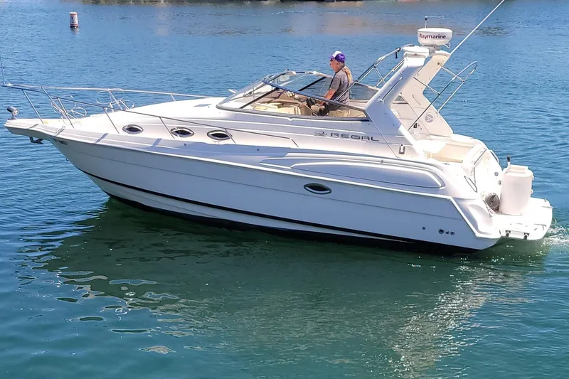 Slide: The Image of 2005 Regal Commodore 2860 boat docked in a marina with palm trees. - 27