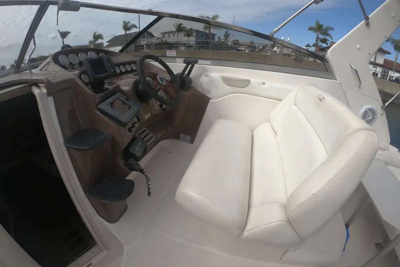 Slide: The Image of Interior of a 2005 Regal Commodore 2860 boat with steering wheel and white seating. - 5