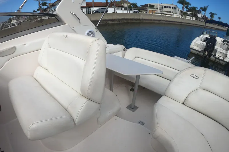 Slide: The Image of Luxurious 2005 Regal Commodore 2860 boat interior with white seating and table, docked by the water. - 7