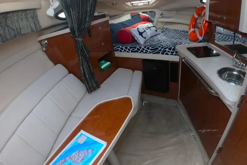 Slide: The Image of Interior of 2005 Regal Commodore 2860 boat with cozy seating and compact kitchenette. - 8