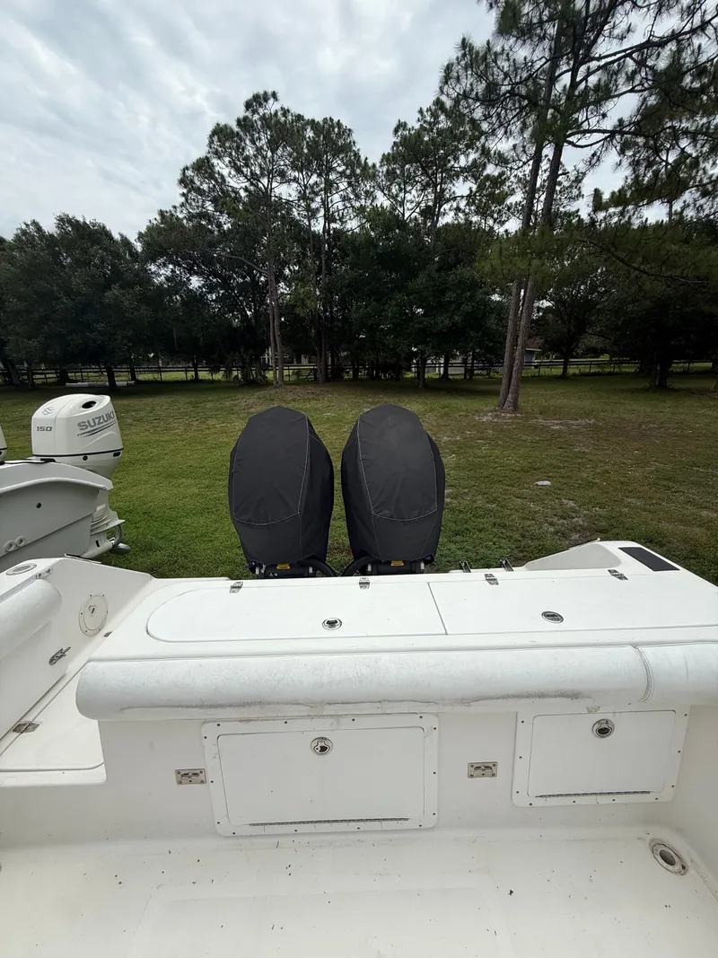 Slide: The Image of 1998 Century 3000 boat with Suzuki engines, parked on grass. - 14
