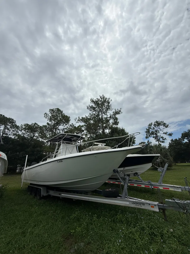 Slide: The Image of Century 3000 boat from 1998 on a trailer outdoors. - 23
