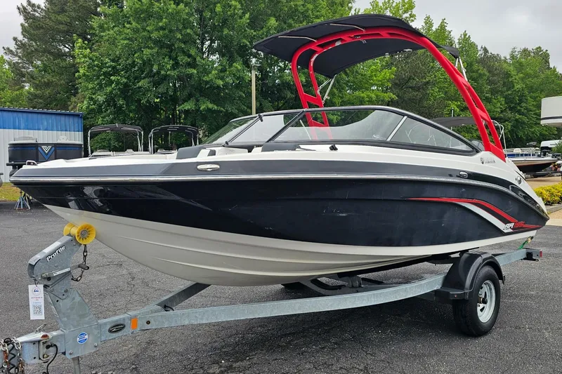 The Image of 2019 Yamaha Boats AR195 on trailer, featuring sleek black and white design with red accents. - 1