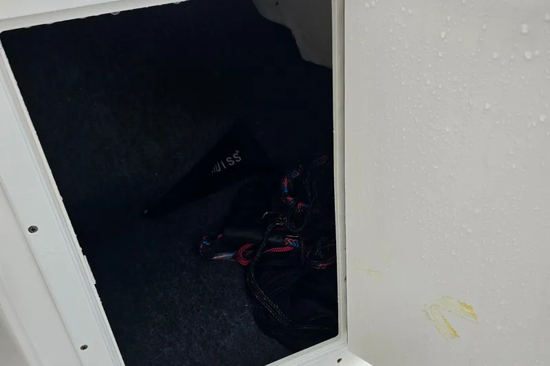 Slide: The Image of Storage compartment of a 2019 Yamaha Boats AR195, featuring ropes and equipment. - 23