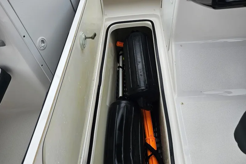 Slide: The Image of Storage compartment in a 2019 Yamaha AR195 boat, containing safety equipment and accessories. - 24