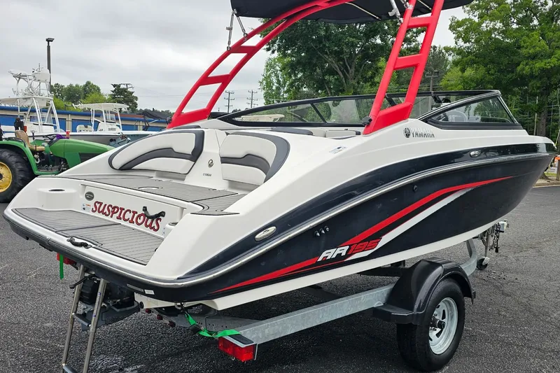 Slide: The Image of 2019 Yamaha AR195 boat with red accents on a trailer, parked outdoors. - 3