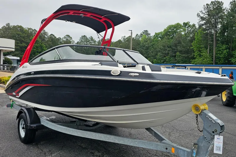 Slide: The Image of 2019 Yamaha Boats AR195 on trailer, black and white with red accents, parked outdoors. - 4