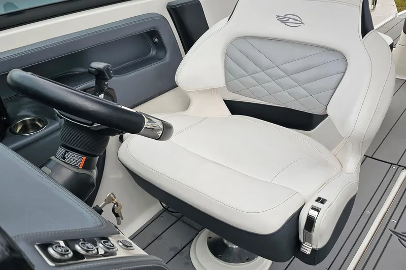 Slide: The Image of Captain's seat and steering wheel of 2021 Chaparral 307 SSX boat interior. - 12