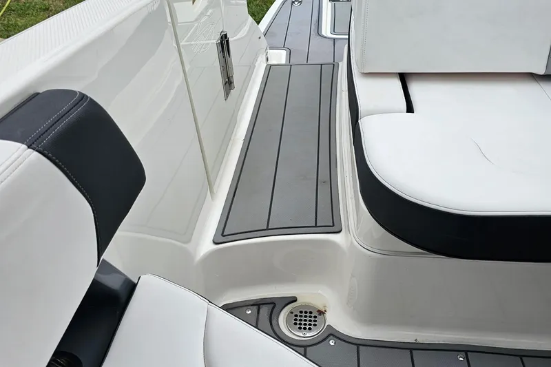 Slide: The Image of 2021 Chaparral 307 SSX boat interior with white seating and non-slip flooring. - 16
