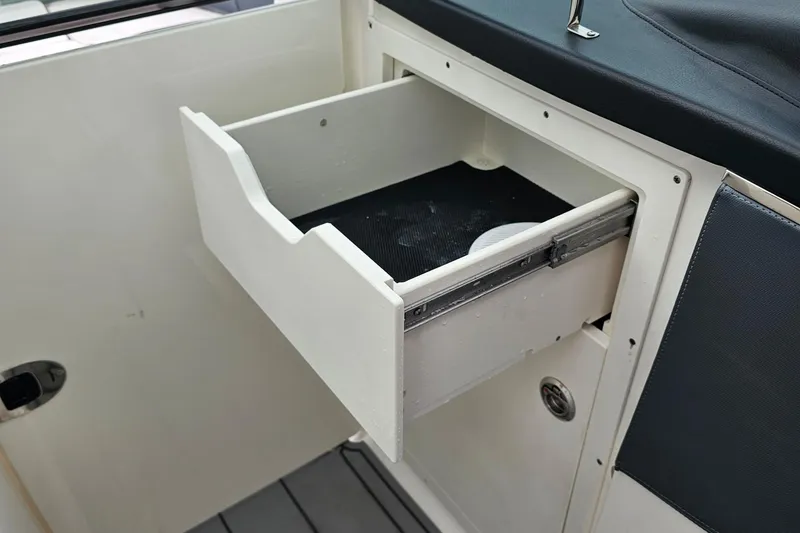 Slide: The Image of Open storage drawer in 2021 Chaparral 307 SSX boat interior. - 25
