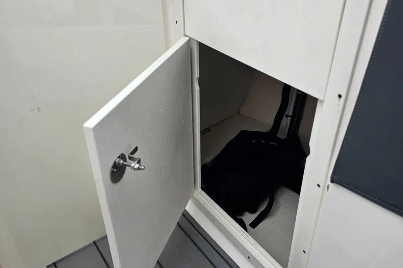 Slide: The Image of Open storage compartment on 2021 Chaparral 307 SSX boat, showing interior space. - 26