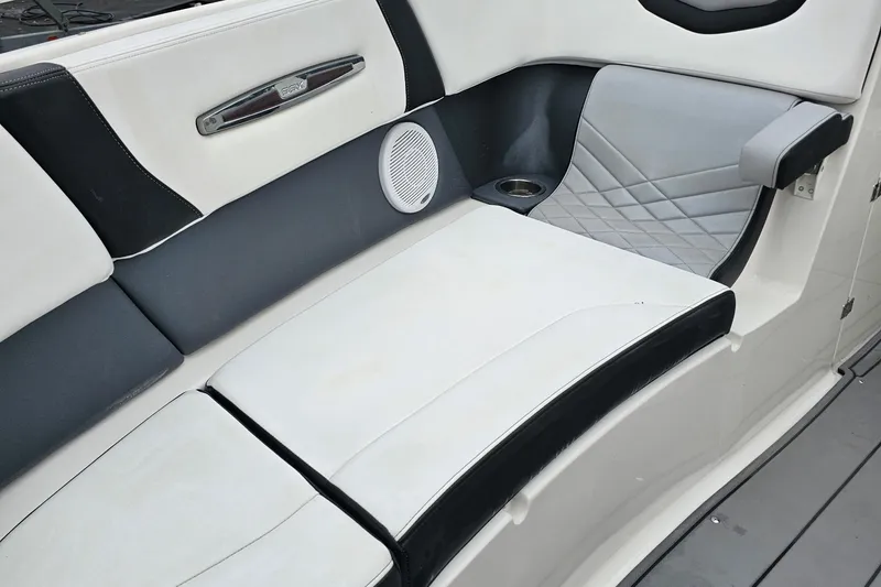 Slide: The Image of 2021 Chaparral 307 SSX boat interior with white and black seating, speaker, and cup holder. - 31