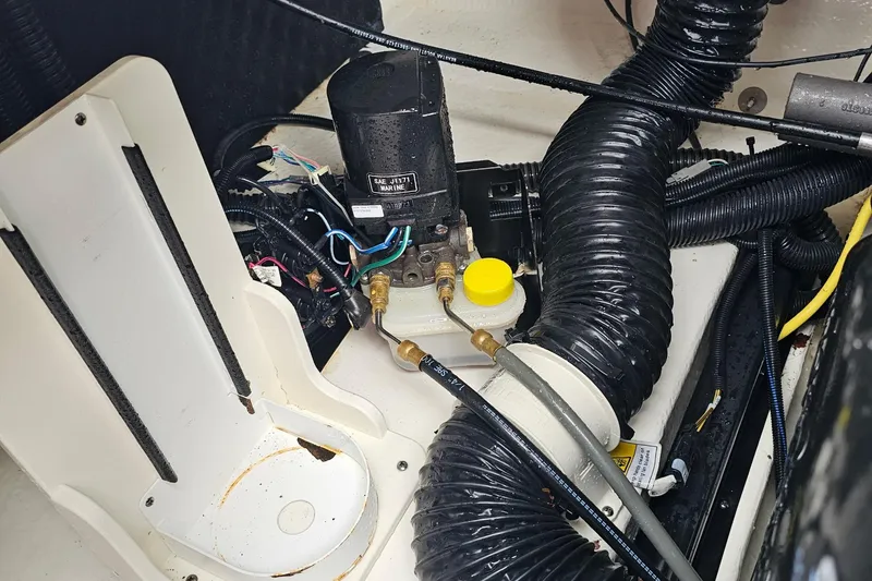Slide: The Image of Engine compartment of a 2021 Chaparral 307 SSX boat, featuring hoses and mechanical components. - 35