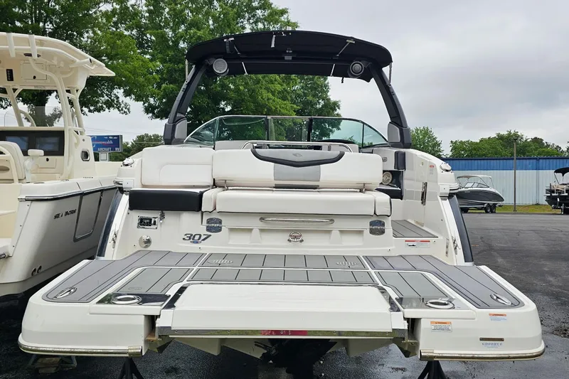 Slide: The Image of 2021 Chaparral 307 SSX boat with sleek design and spacious deck, displayed outdoors. - 5