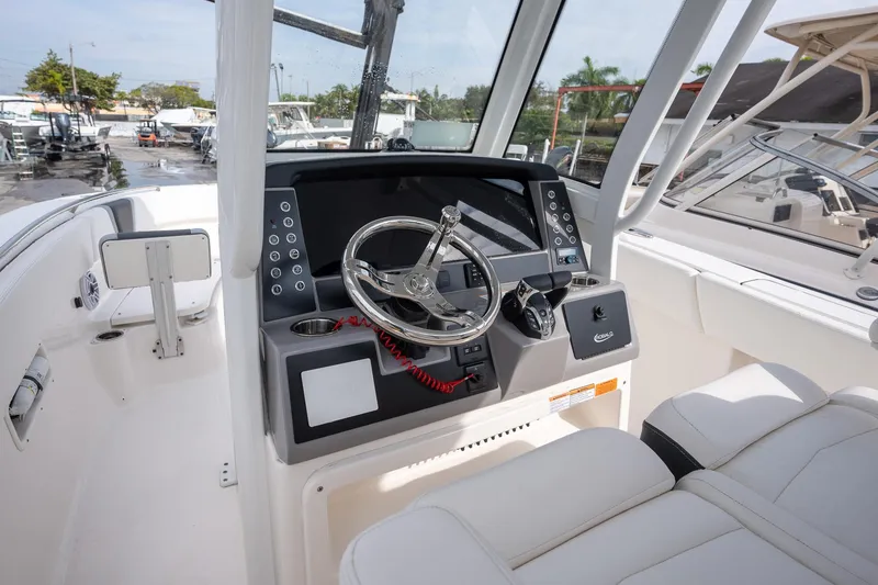 Slide: The Image of 2025 Robalo R270 Center Console boat interior with modern steering and controls. - 12