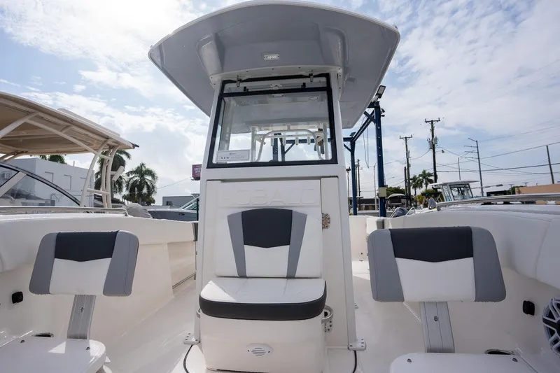 Slide: The Image of 2025 Robalo R270 Center Console boat interior with seating and console, under a partly cloudy sky. - 13