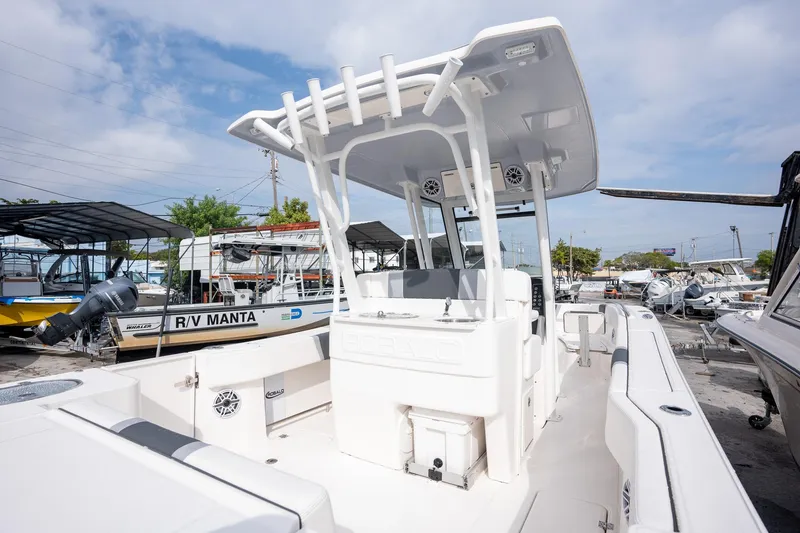 Slide: The Image of 2025 Robalo R270 Center Console boat in a marina, showcasing sleek design and spacious deck. - 7