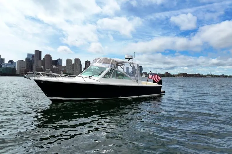 The Image of 2020 Hunt Yachts Harrier 26 cruising near city skyline under blue skies. - 0