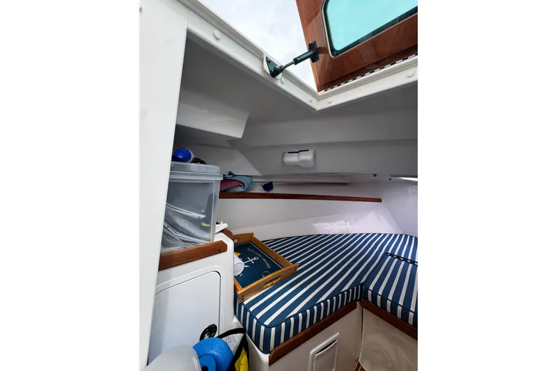 Slide: The Image of Interior cabin of 2020 Hunt Yachts Harrier 26 with striped cushions and storage. - 11