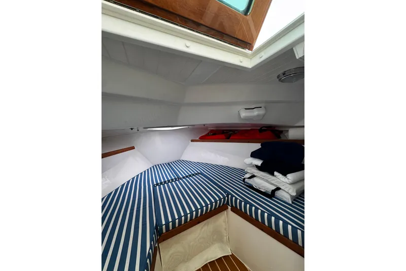 Slide: The Image of Interior cabin of 2020 Hunt Yachts Harrier 26 with striped cushions and storage. - 12