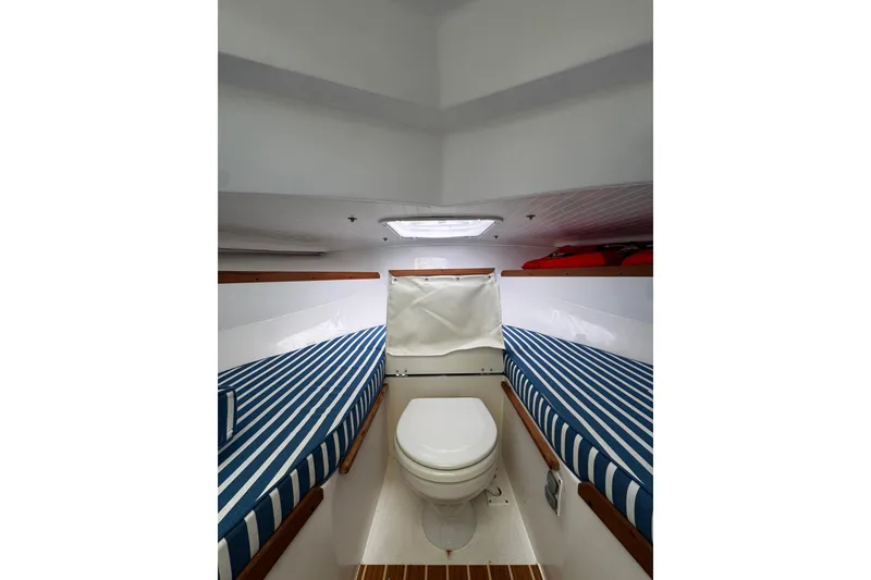 Slide: The Image of Interior cabin of 2020 Hunt Yachts Harrier 26 with striped cushions and compact toilet. - 14