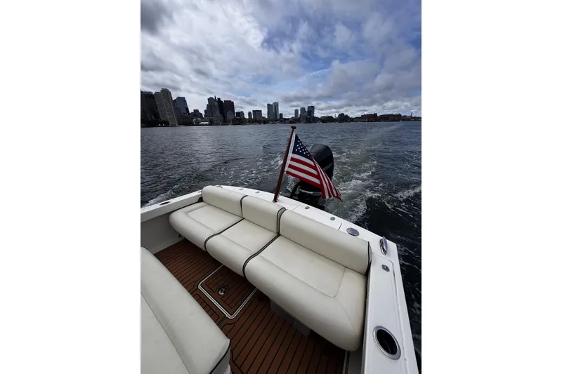Slide: The Image of 2020 Hunt Yachts Harrier 26 cruising with city skyline and American flag. - 19
