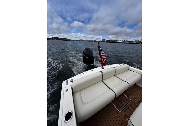 Slide: The Image of 2020 Hunt Yachts Harrier 26 cruising on open water with American flag and outboard motor. - 20